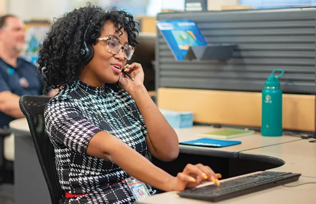 OUC customer service employee on the phone, highlighting professional careers.