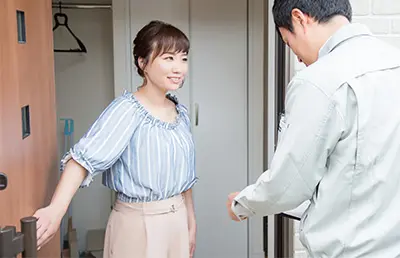 A woman answering the door as a man claiming to be a utility representative demands bill payment. 