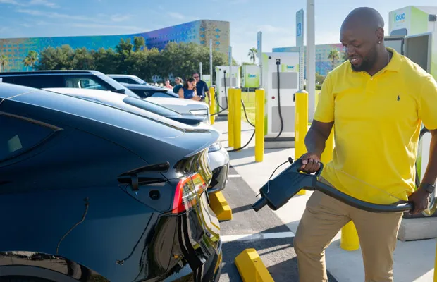 Man charges his electric vehicle outside of the Orange County Convention Center