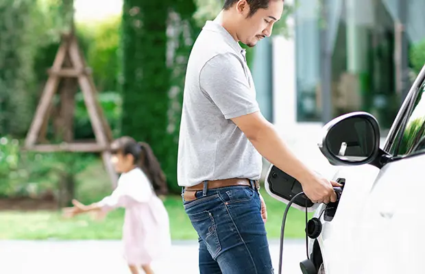 A man charging his vehicle at home