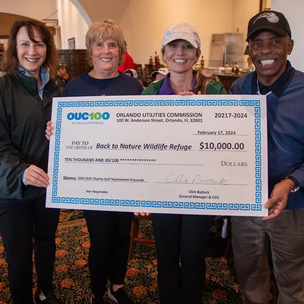 OUC presents a check to the Back to nature Wildlife Refuge