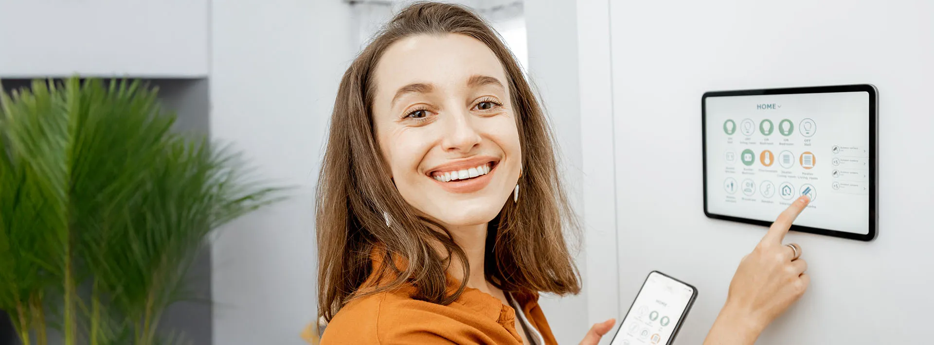 Woman adjusting smart thermostat.