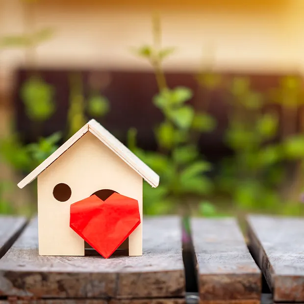 Small wooden toy house with a heart in front