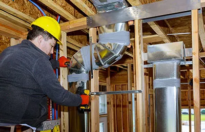 A contractor repairing duct work.