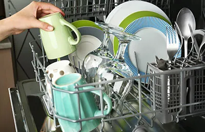 An open dishwasher with plates inside.