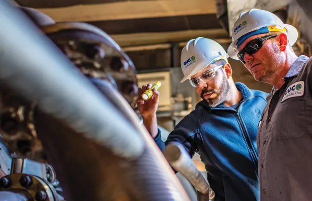 OUC skilled trade workers examining a water line.