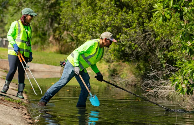 OUC employee cleaning a public park