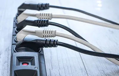 Multiple electrical appliances plugged into a surge protector.