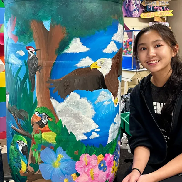 Student next to her Water Color Project rain barrel artwork